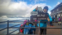 Foto von Christian Berg am Gipfel des Fujis mit Angabe der Seehöhe von 3.250m
